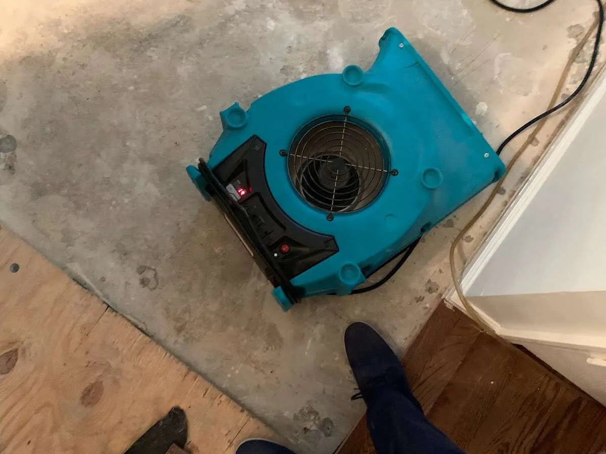 Air mover drying subfloor during Leak Detection & Repair in Cadillac